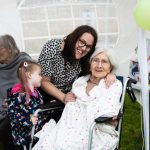 manor house residential care having Summer Fair. The image shows an elderly resident enjoying the fair with the family